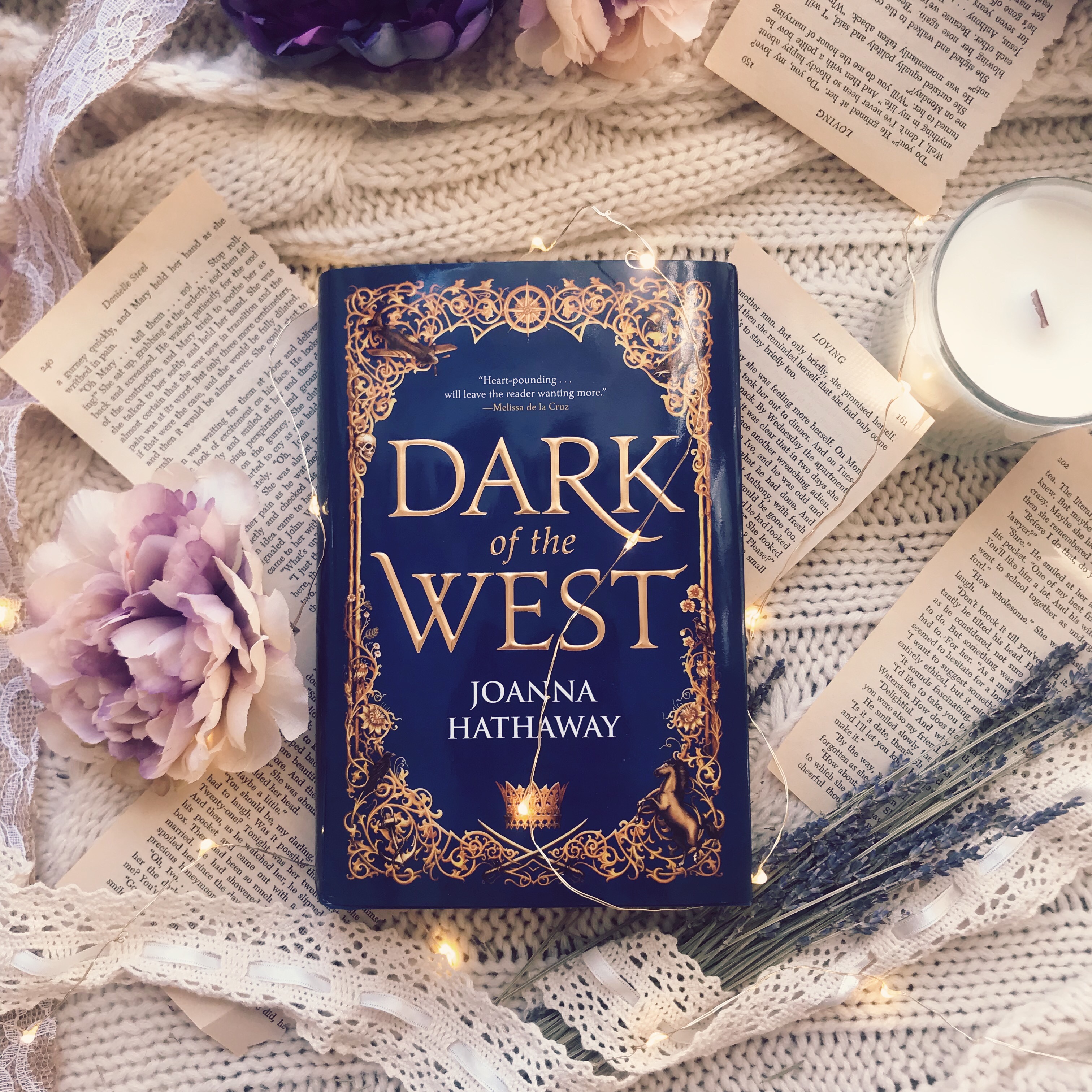 Dark of the West laid on a blanket and scattered pages, along with dried lavender and a Alchemy and Ink Candle. 