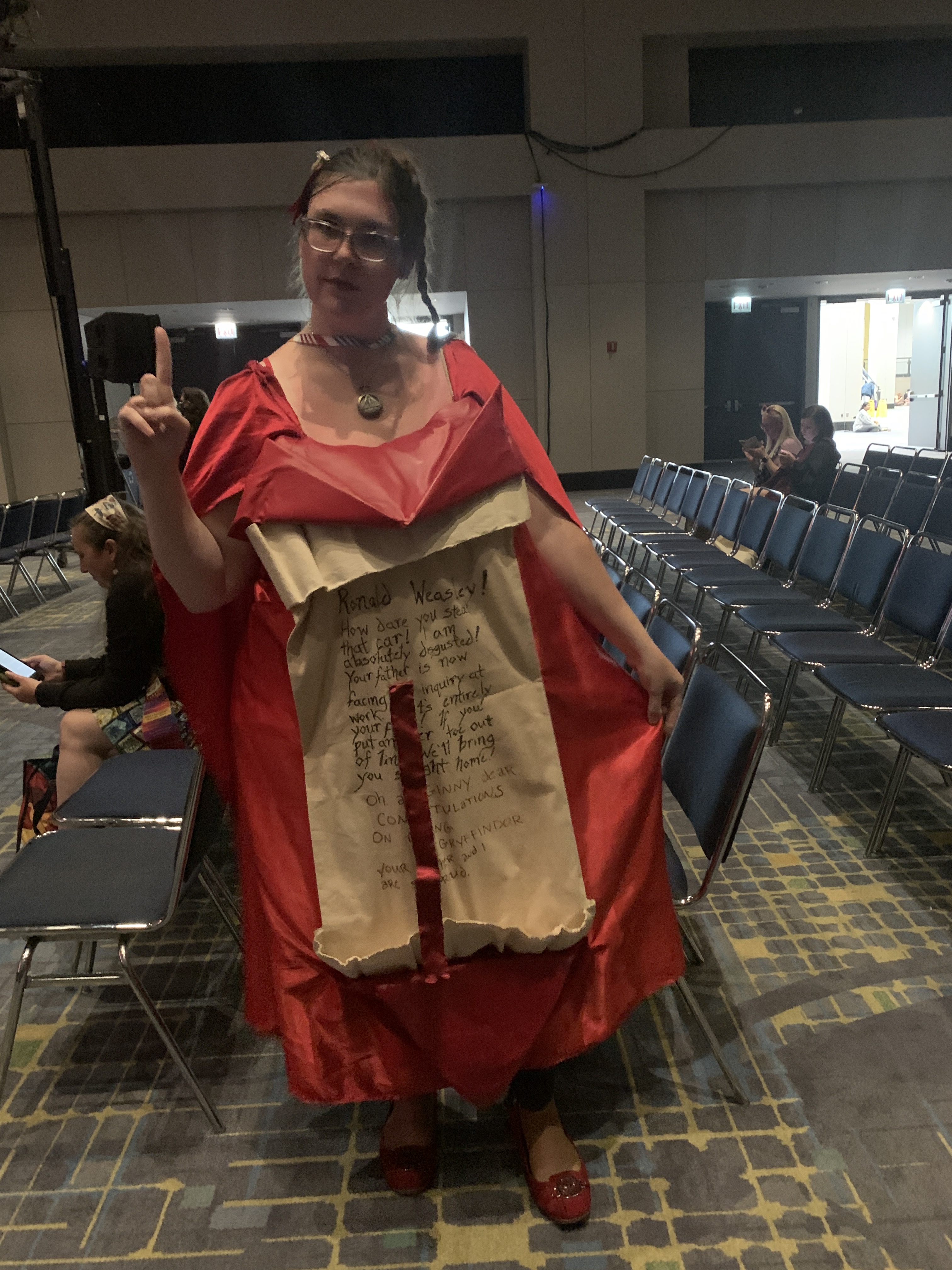 A woman holding her finger up dressed as Molly Weasley's howler to Ron in the Chamber of Secrets.