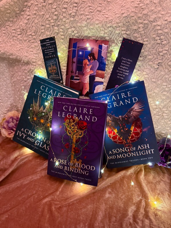 The Middlemist series with their featured bookmarks and an art print of Ferrin and Ryder behind the books all covered in fairy lights.
