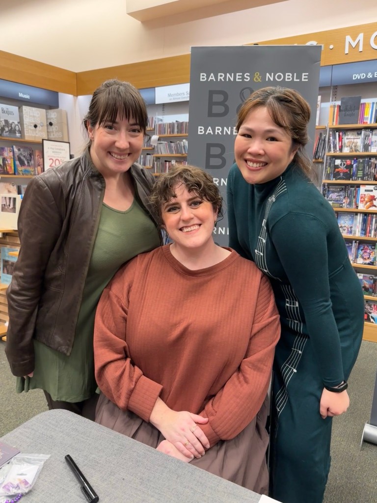 Claire Legrand sitting in the middle with Kaite and her friend Sam standing around her dressed as Mara and Ferrin respectively